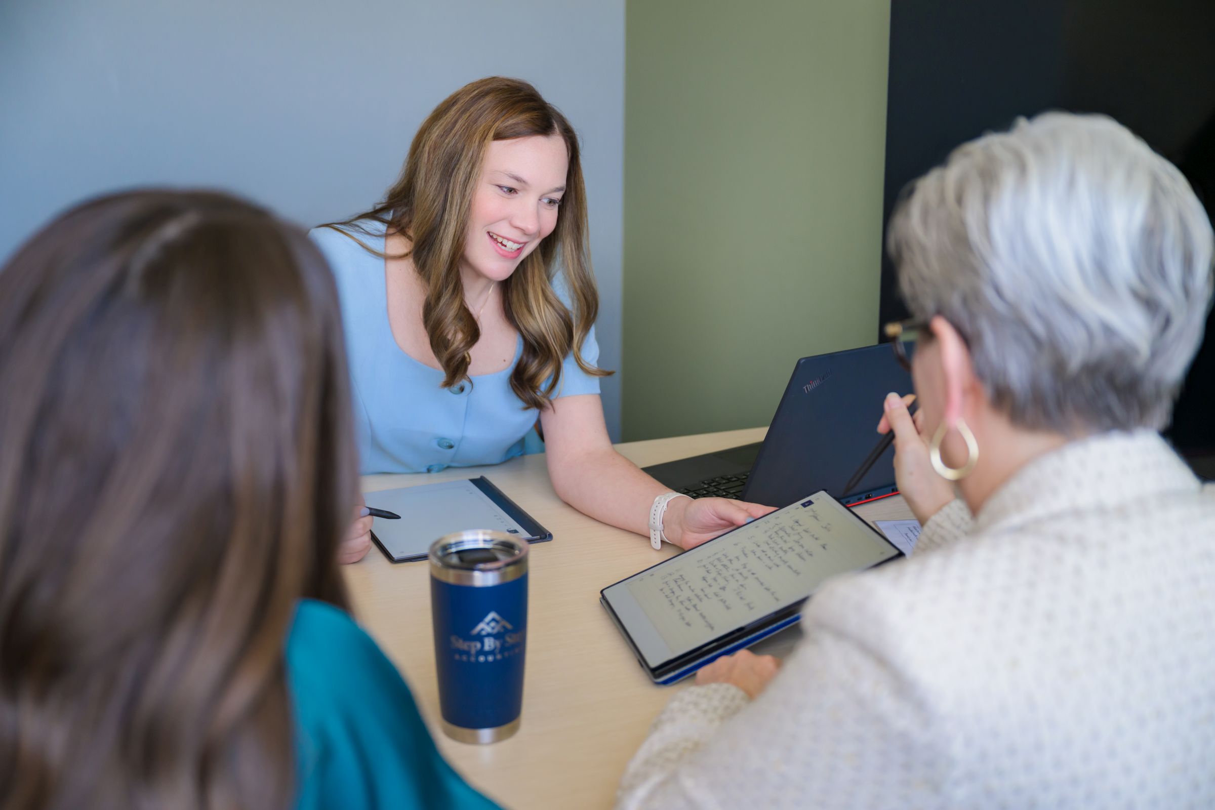 Accounting professional meets with clients to discuss financial reports.