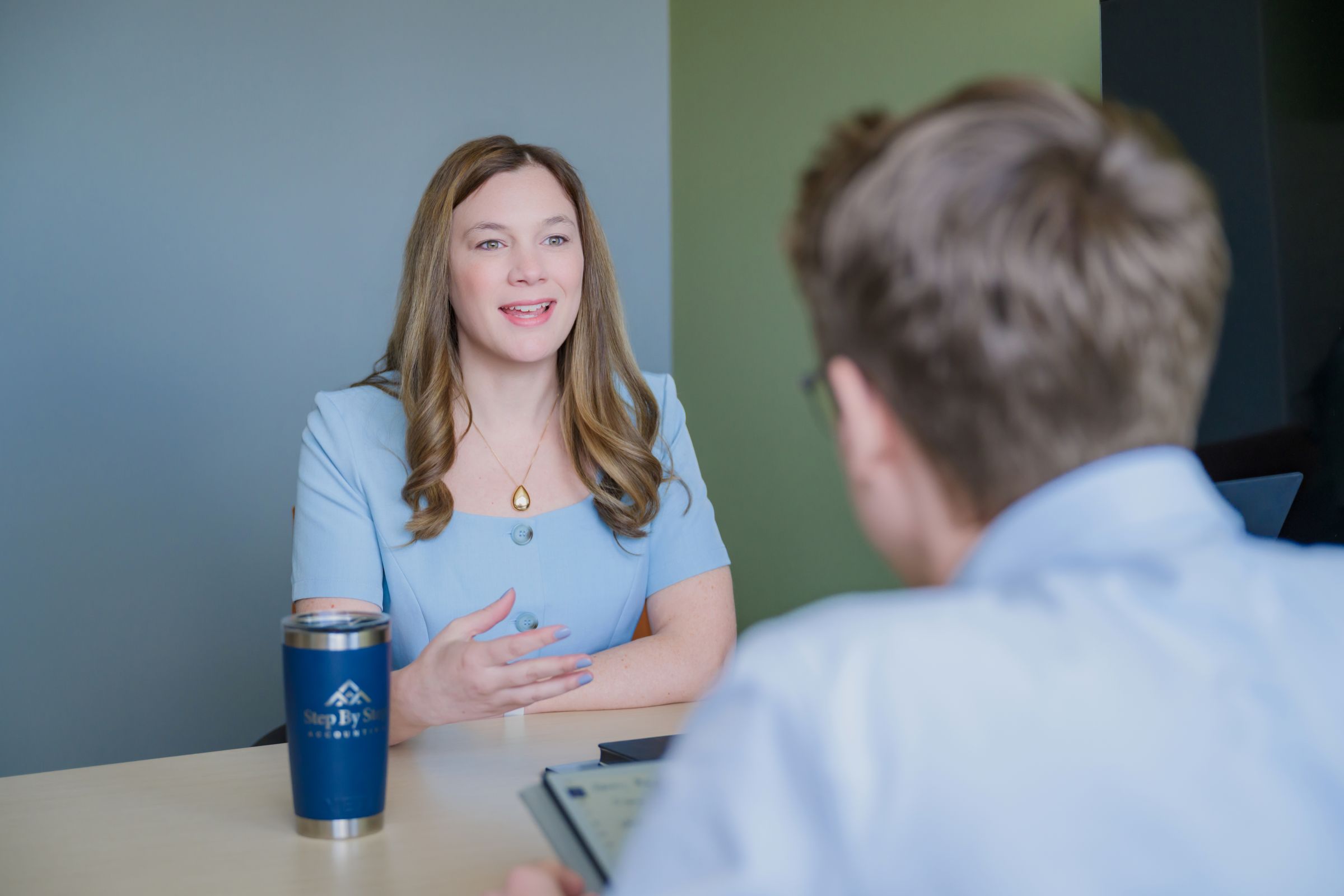 A man and woman meet in a professional setting.
